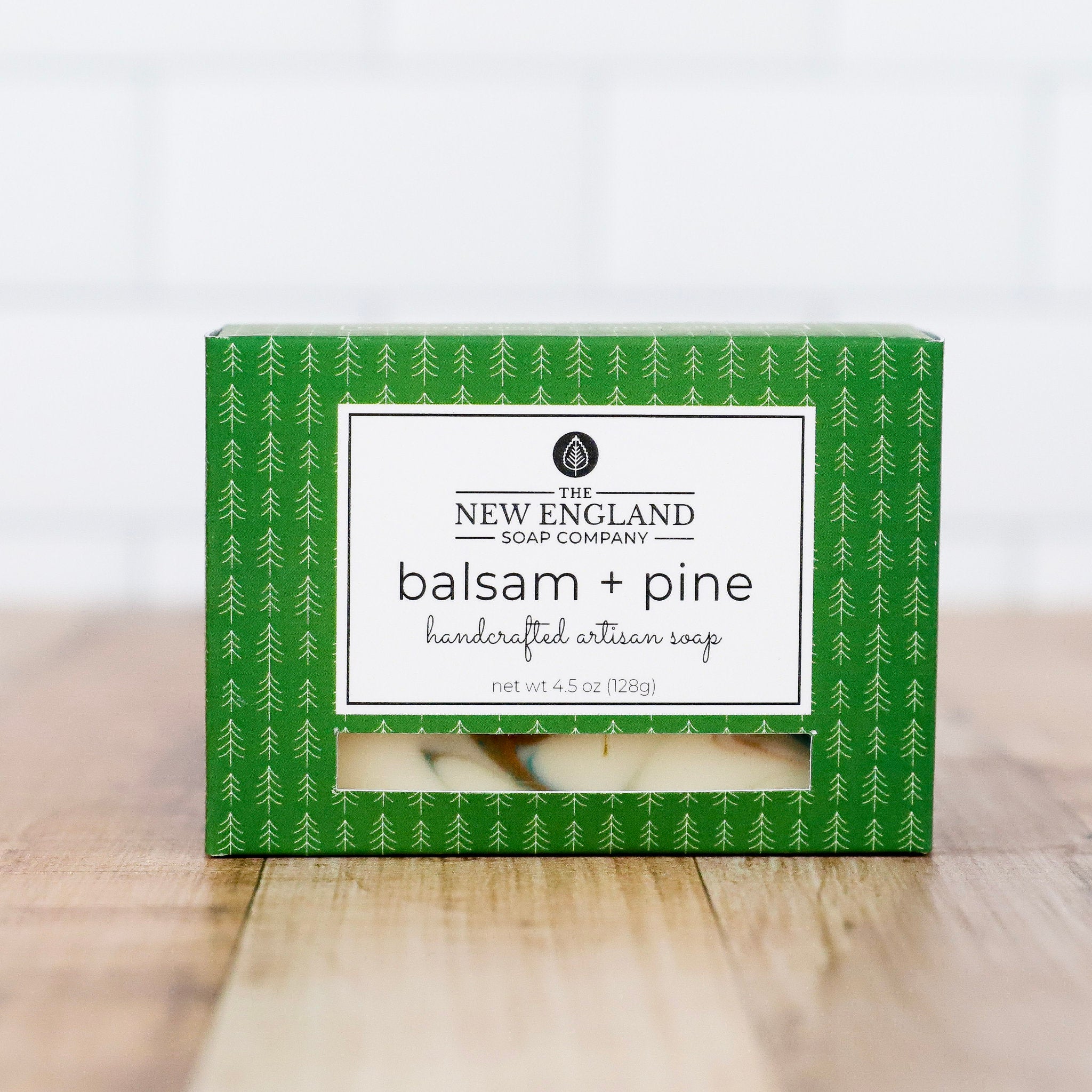 Box of New England Soap Company balsam + pine soap on a wooden surface with a white background