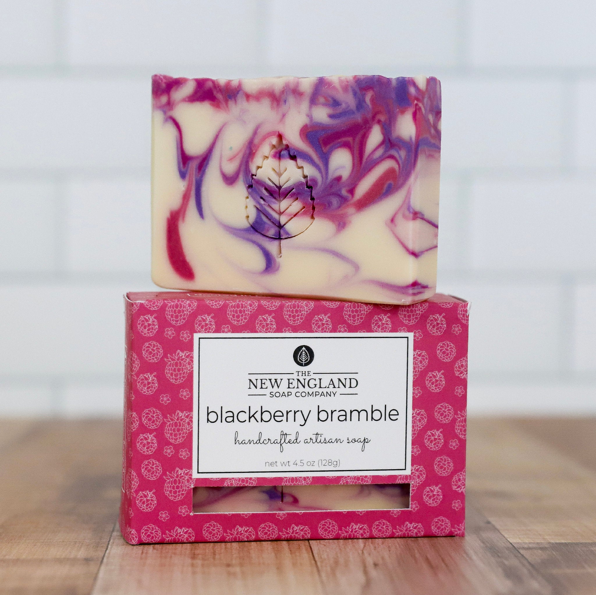 Handcrafted artisan soap with marbled design and decorative packaging on a wooden surface.