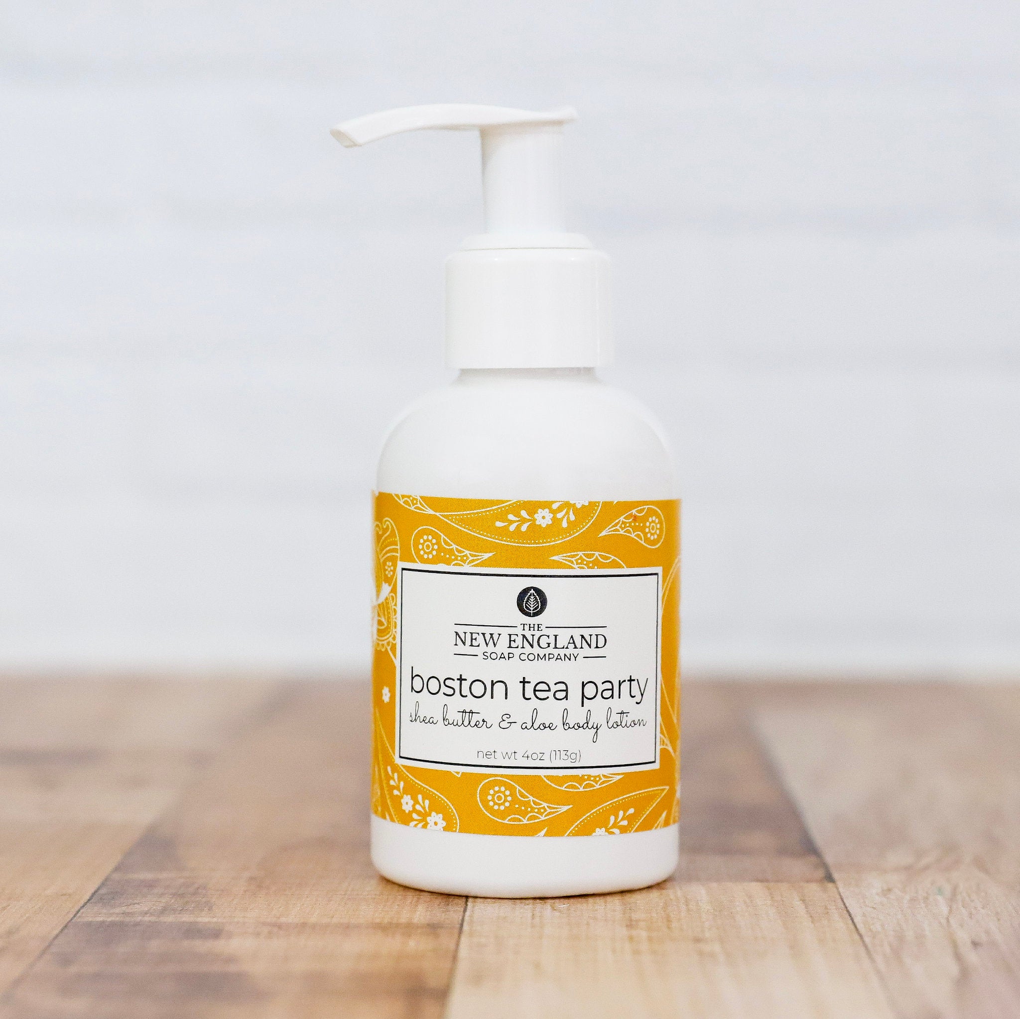 Body lotion bottle with yellow label on a wooden surface