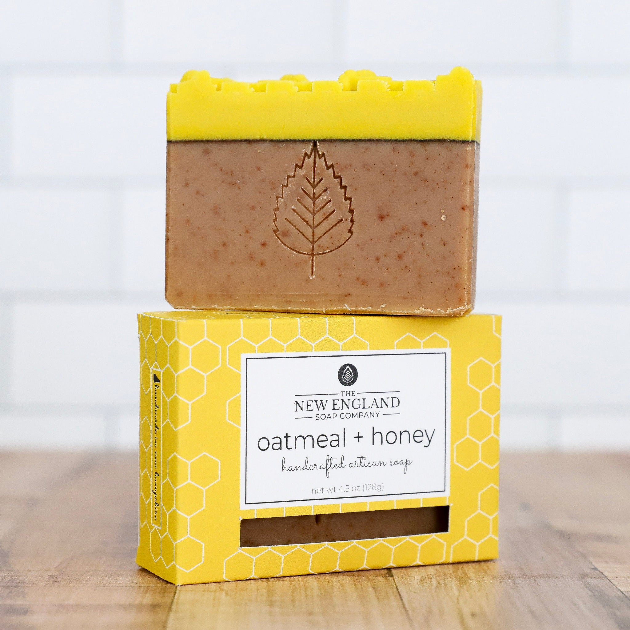 Bar of oatmeal and honey soap on a yellow box with &