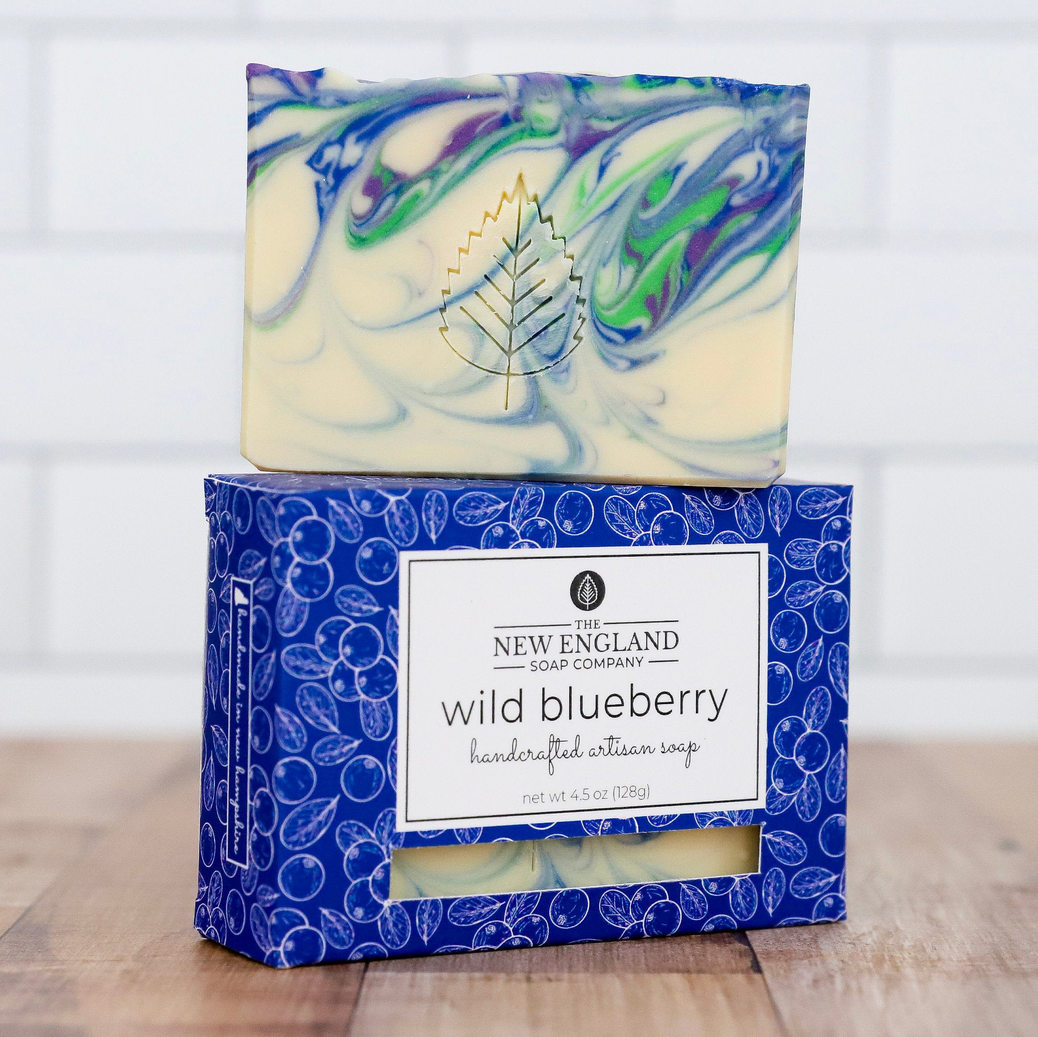 Handcrafted artisan soap with a blue box packaging on a wooden surface