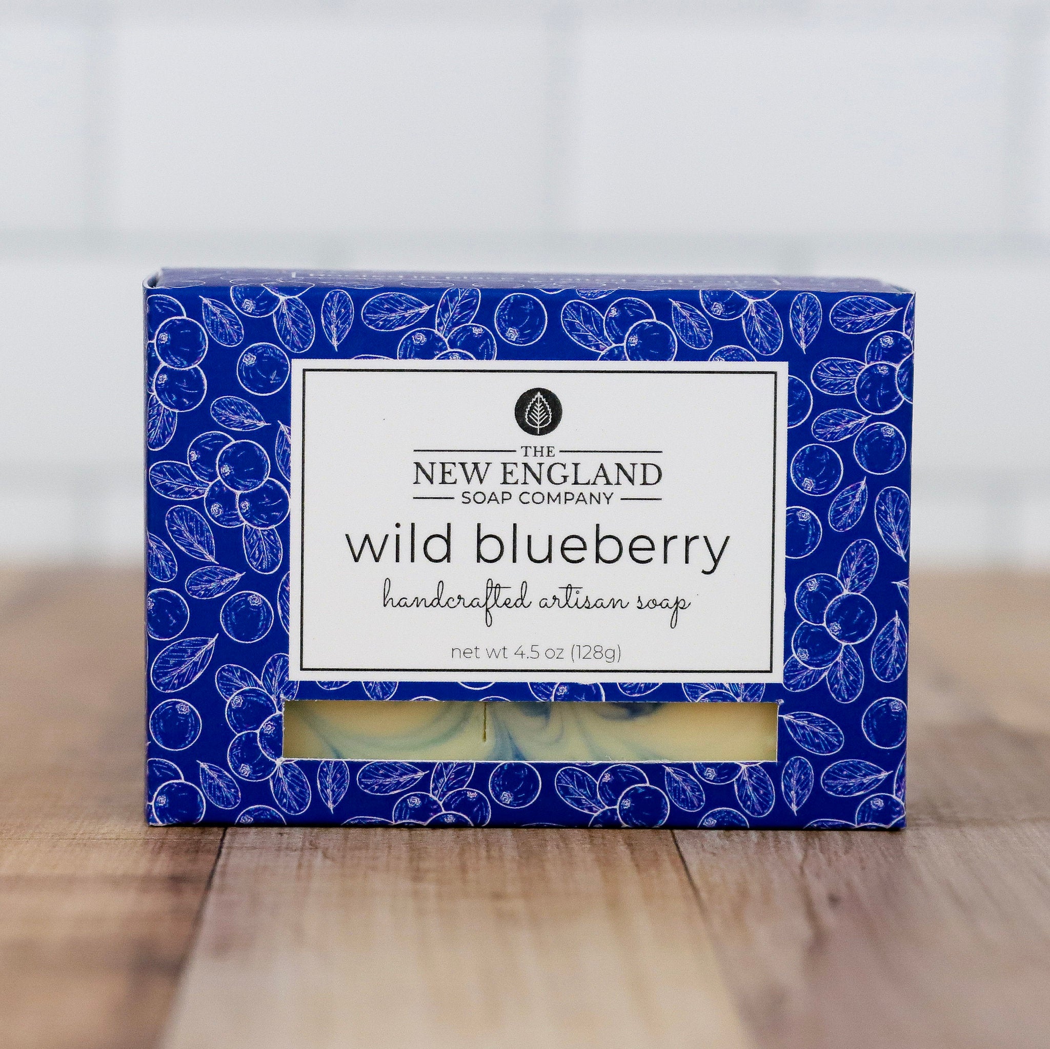 Box of New England Soap Company wild blueberry soap on a wooden surface with a white background