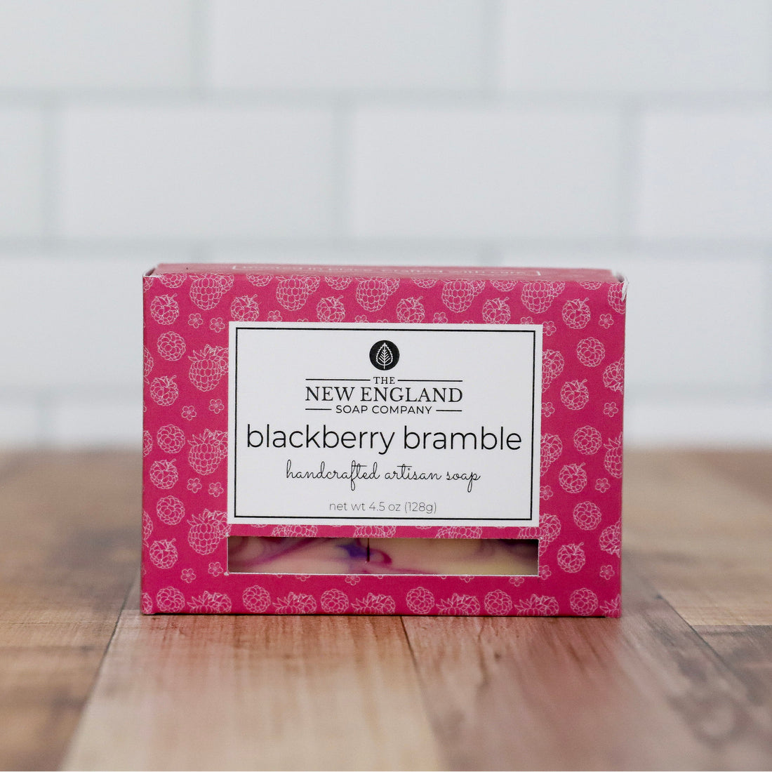 Pink box of New England Soap Company blackberry bramble soap on a wooden surface with a white background