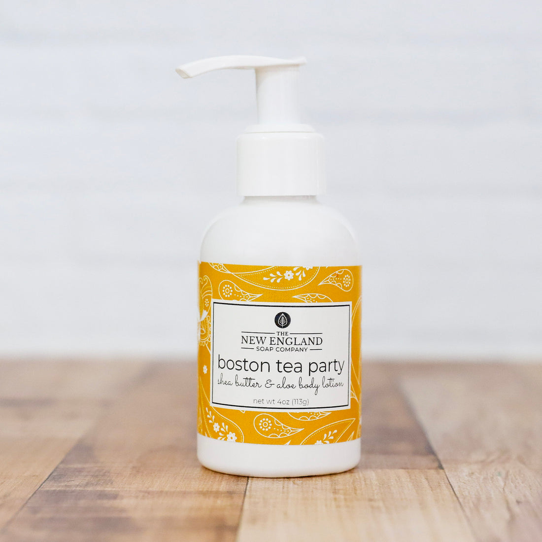 Body lotion bottle with yellow label on a wooden surface