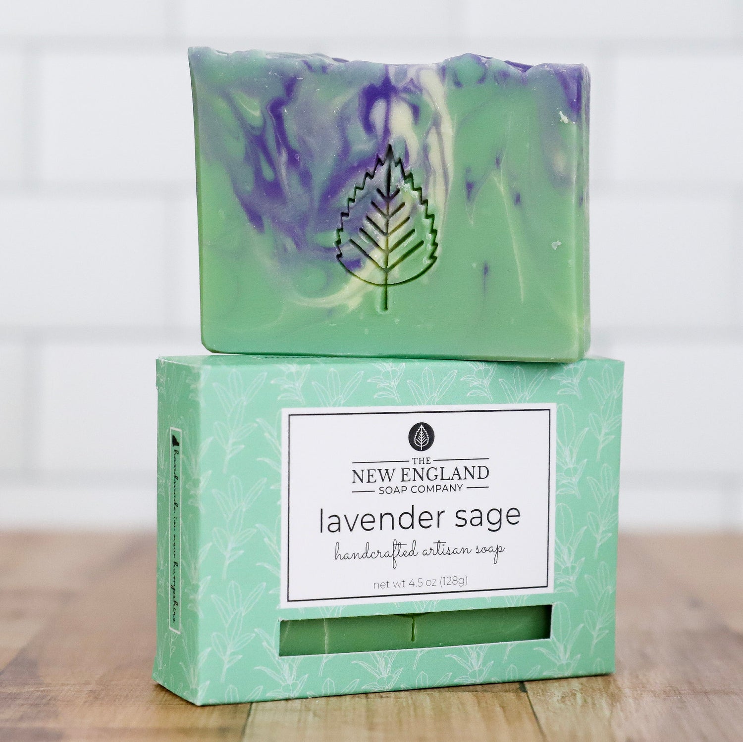 Bar of lavender sage soap with packaging on a wooden surface