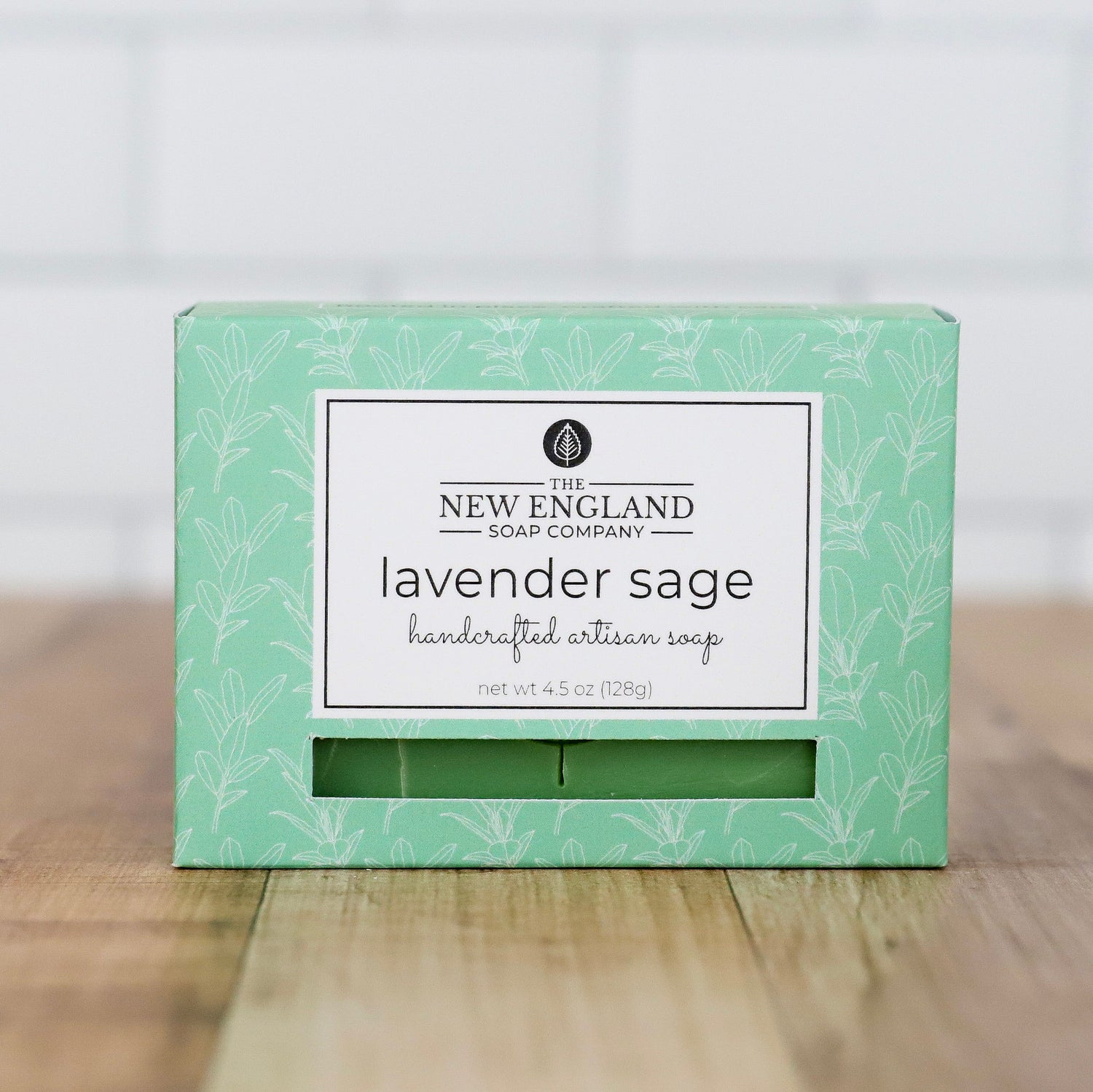 Green box of lavender sage soap from The New England Soap Company on a wooden surface.