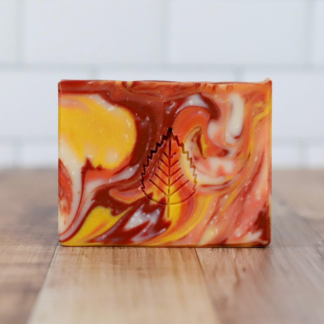 Swirled soap bar with autumn colors on a wooden surface Trailhead Artisan Soap