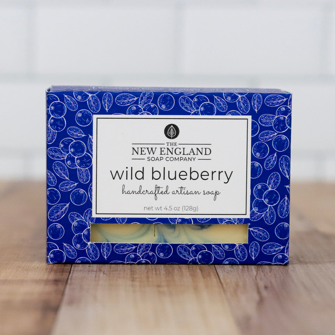 Box of New England Soap Company wild blueberry soap on a wooden surface with a white background